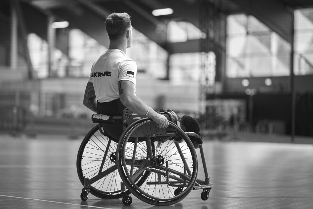 Ausstellung Spirit of Invictus Games Düsseldorf 2023 Rollstuhl Basketballspieler aus der Ukraine von hinten im Gegenlicht