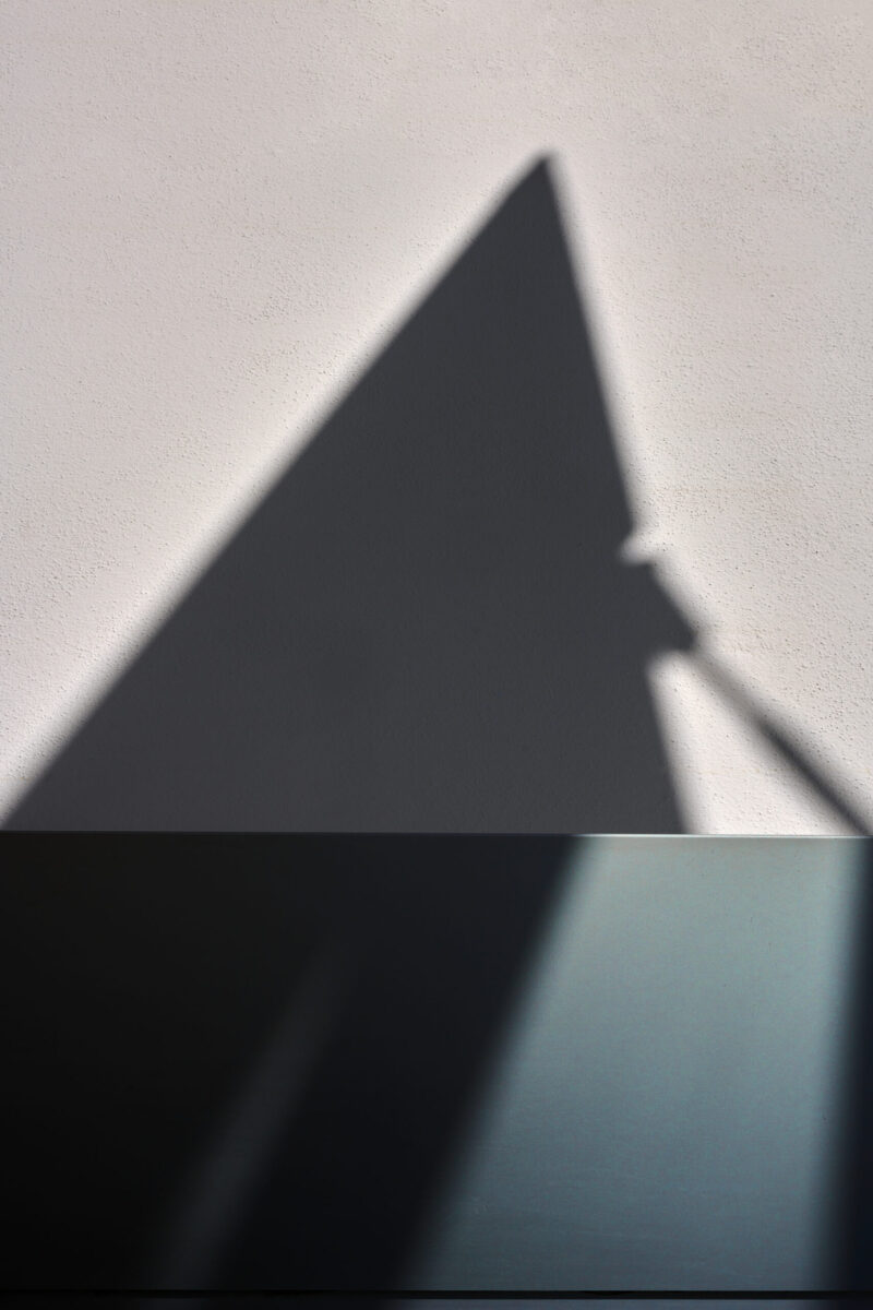 abstrakter minimalistischer horizontaler Ausschnitt einer Haus-fassade mit schrägem überlagerndem Schattenverlauf, Hochformat