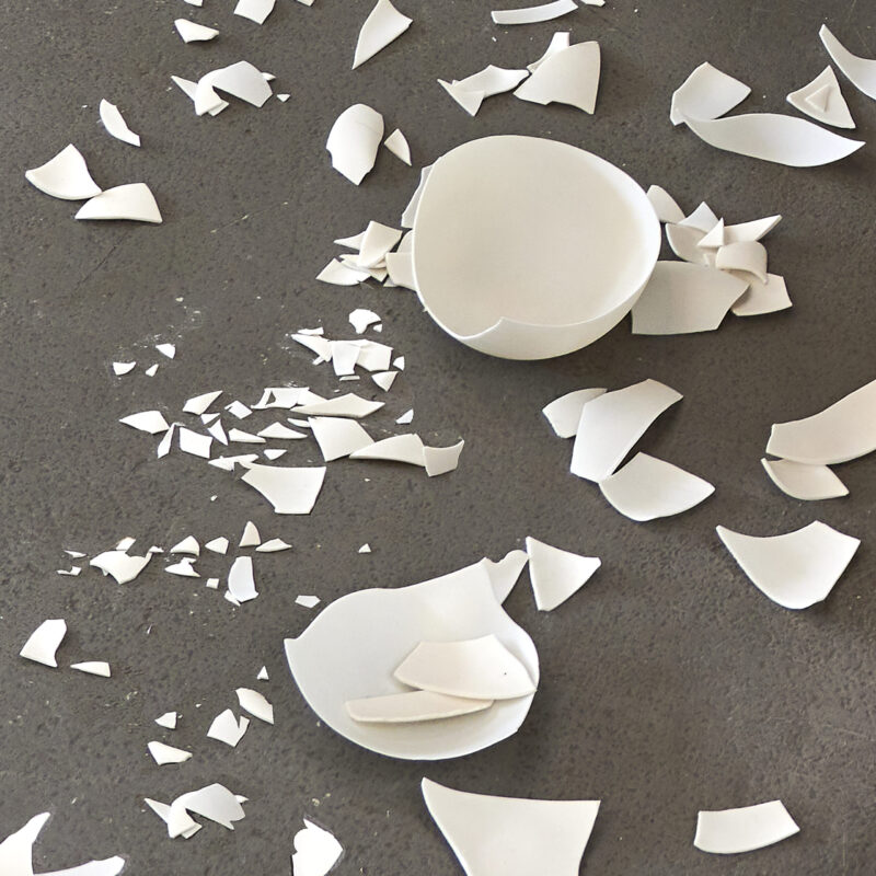 Eventfotografie Düsseldorf Ausstellung "72 Stunden - ein Zeitraum" von Corinna Bernshaus - Detail von Installation Tisch, zerbrochene Porzellanschalen und Scherben auf dem Boden