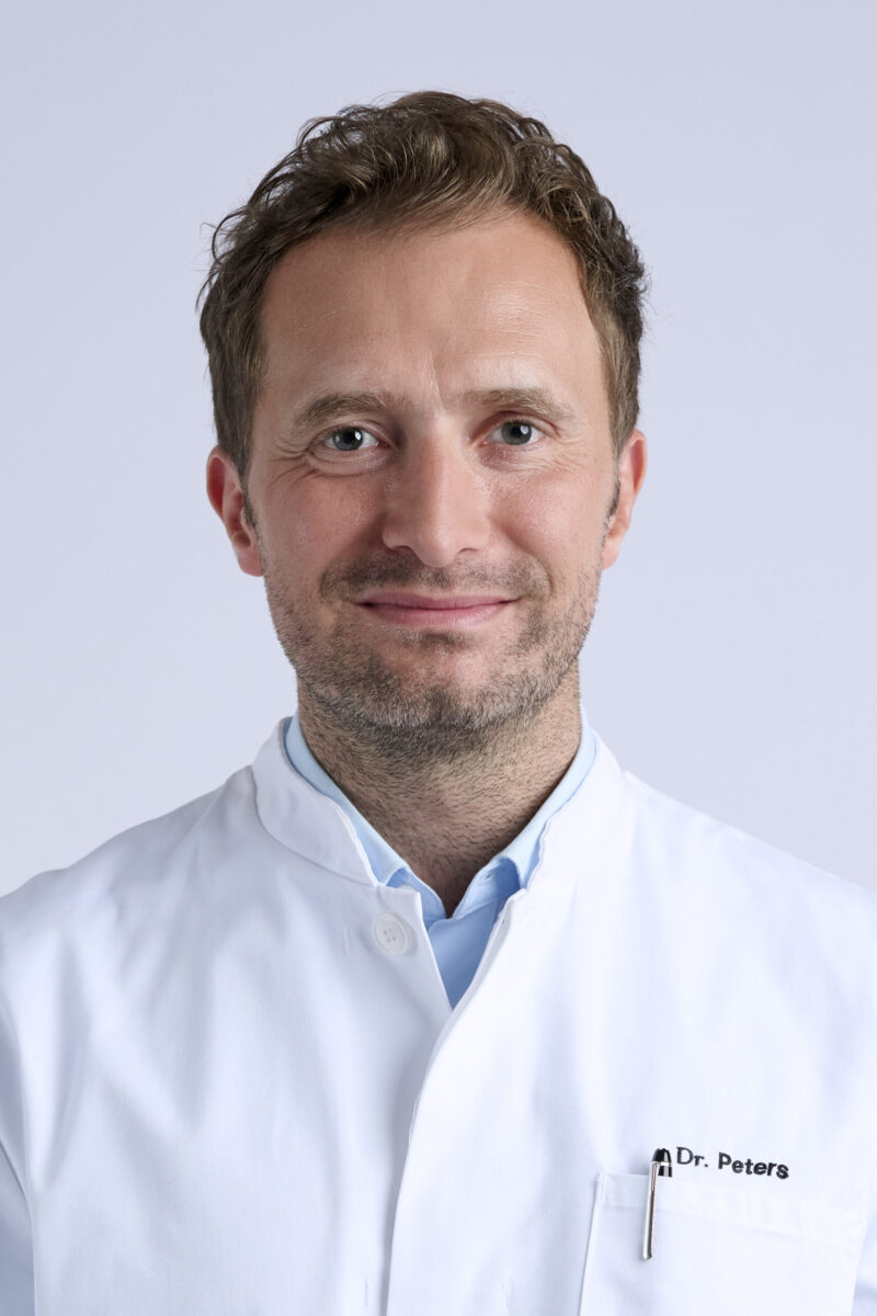 Peoplefotografie Düsseldorf, Business Porträts Düsseldorf Klassisches Businessporträt eines dunkelhaarigen Arztes vor hellem Hintergrund