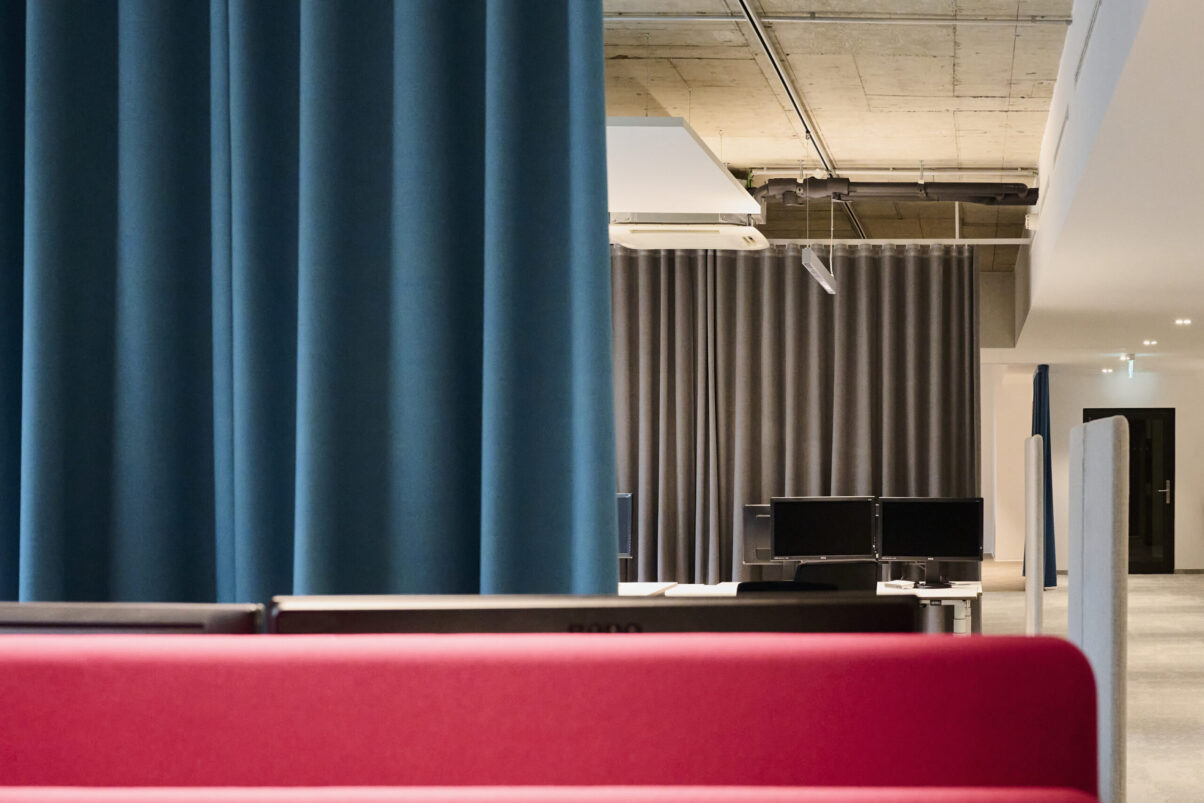 Architektur- und Interieurfotografie Düsseldorf Auxmoney, Ausschnitt Großraumbüro mit Farbkonzept rot/petrol/schwarz/grau