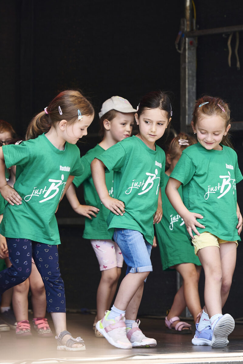 Eventfotografie Düsseldorf Sonnenrad Festival 2023 - Kindertanzgruppe in grünen T-Shirts