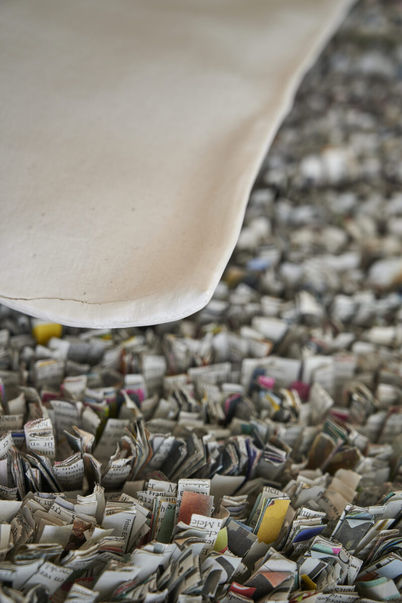 Eventfotografie Düsseldorf Ausstellung "72 Stunden - ein Zeitraum" von Corinna Bernshaus - Detailfoto Installation Teppich, geknüpft aus Zeitungsschnipseln, Ecke eines Porzellankissens