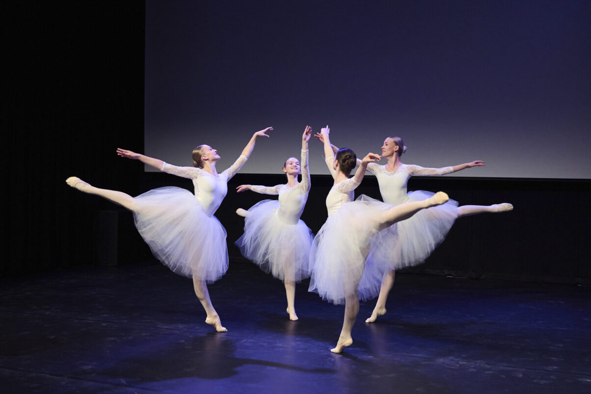 Eventfotografie Düsseldorf Ballettaufführung, klassische Choreographie, 4 Tänzerinnen auf Spitzen posierend in klassischen, weißen "Schwanensee"-Kleidern