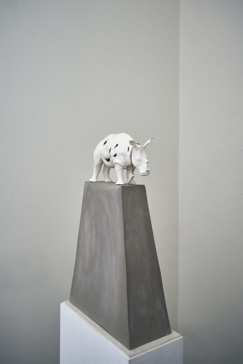 Eventfotografie Düsseldorf Ausstellung "72 Stunden - ein Zeitraum" von Corinna Bernshaus - weißes Nashorn aus Porzellan, trägt sein eigenes Horn als Kette, grauer Block auf weißer Säule