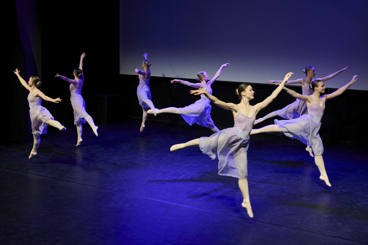 Eventfotografie Düsseldorf Ballettaufführung, klassische Choreographie, Ensemble im Sprung in zarten, fliederfarbenen Kleidern