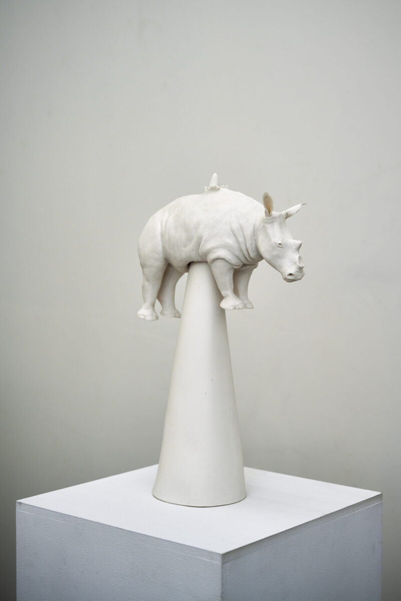 Eventfotografie Düsseldorf Ausstellung "72 Stunden - ein Zeitraum" von Corinna Bernshaus - weißes Nashorn ohne Nashorn aus Porzellan, aufgespießt aus seinem eigenen Horn, weiße Säule