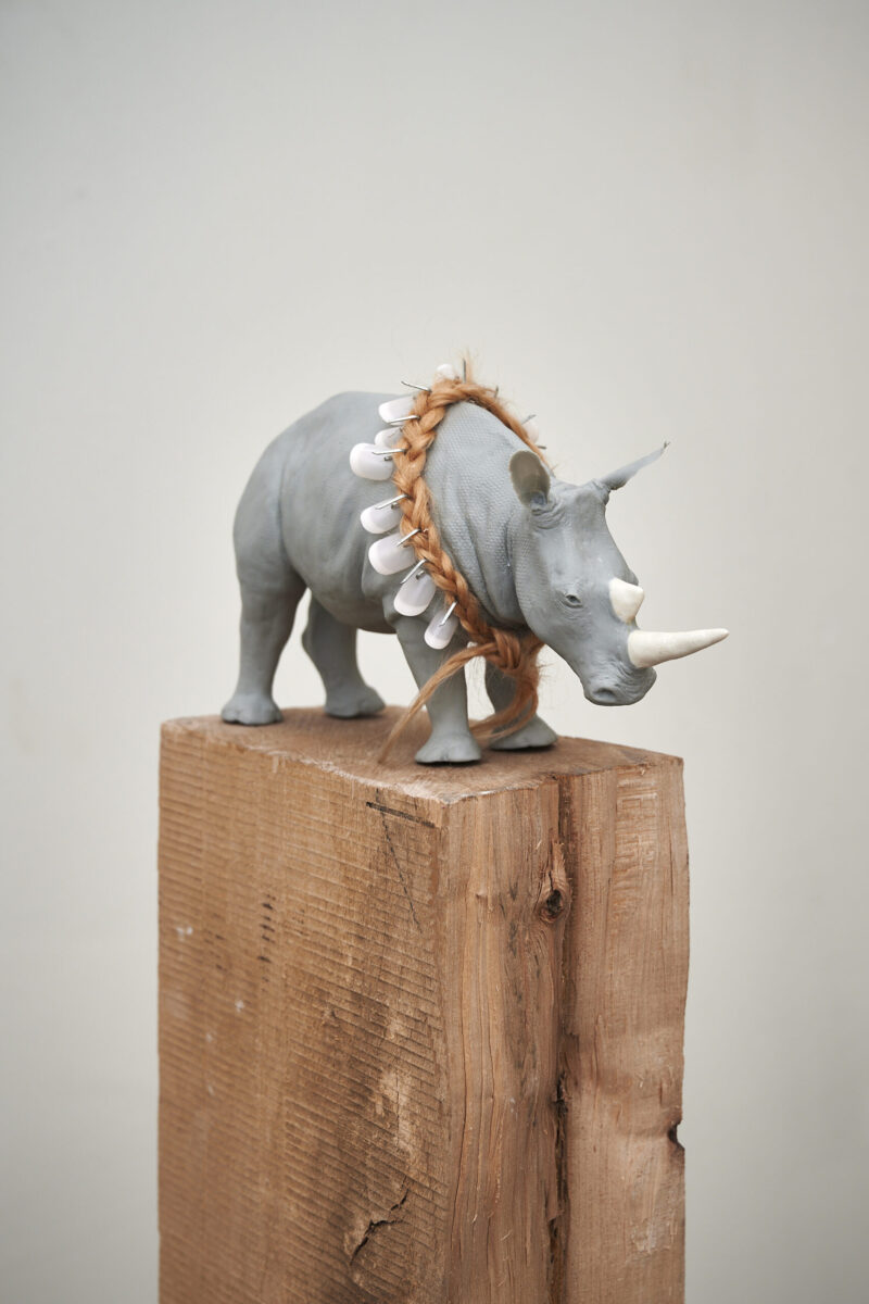 Eventfotografie Düsseldorf Ausstellung "72 Stunden - ein Zeitraum" von Corinna Bernshaus - Porzellanskulptur auf Holzblock, graues Nashorn, Halsband aus Fingernägeln (menschliches Horn)
