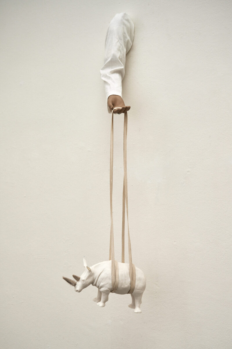 Eventfotografie Düsseldorf Ausstellung "72 Stunden - ein Zeitraum" von Corinna Bernshaus - Wandskulptur aus Porzellan, Arm mit Hand hält ein Nashorn in einem Gurt