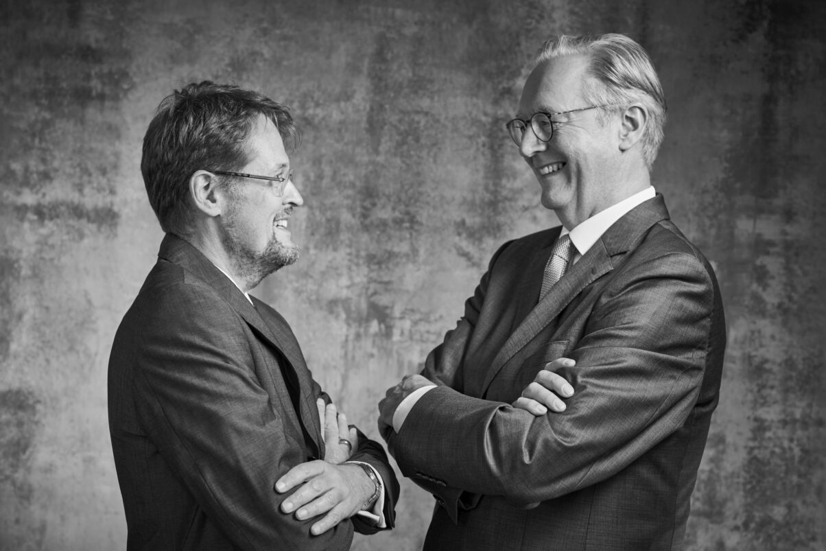 Peoplefotografie Düsseldorf, Business Porträts Düsseldorf Schwarzweißfotografie von zwei Vorständen im Anzug die sich gegenüberstehen und lachen