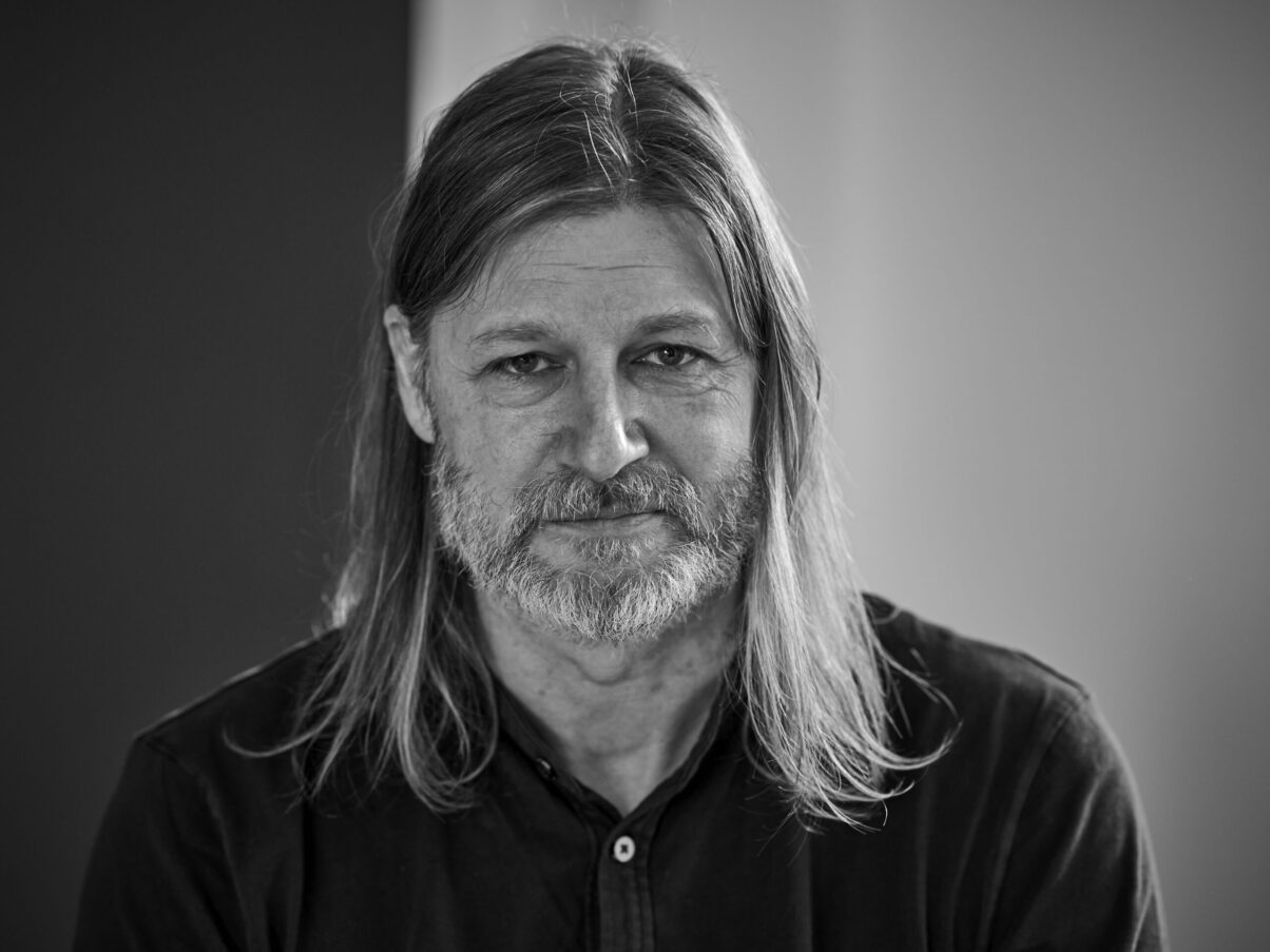 Mann mit langen Haaren und coolem Blick, Schwarzweißfoto