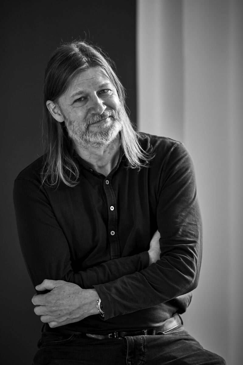 Mann mit langen Haaren und coolem Blick, Schwarzweißfoto