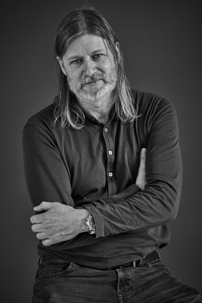 Mann mit langen Haaren und coolem Blick, Schwarzweißfoto