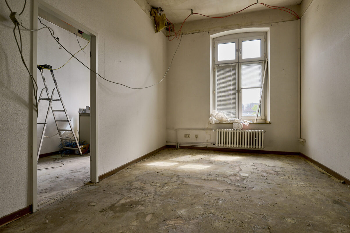 Architektur- und Interieurfotografie Düsseldorf SKFM Sanierung Altbau, zwei Räume in der Sanierungsphase mit Leiter und herabhängenden Kabeln
