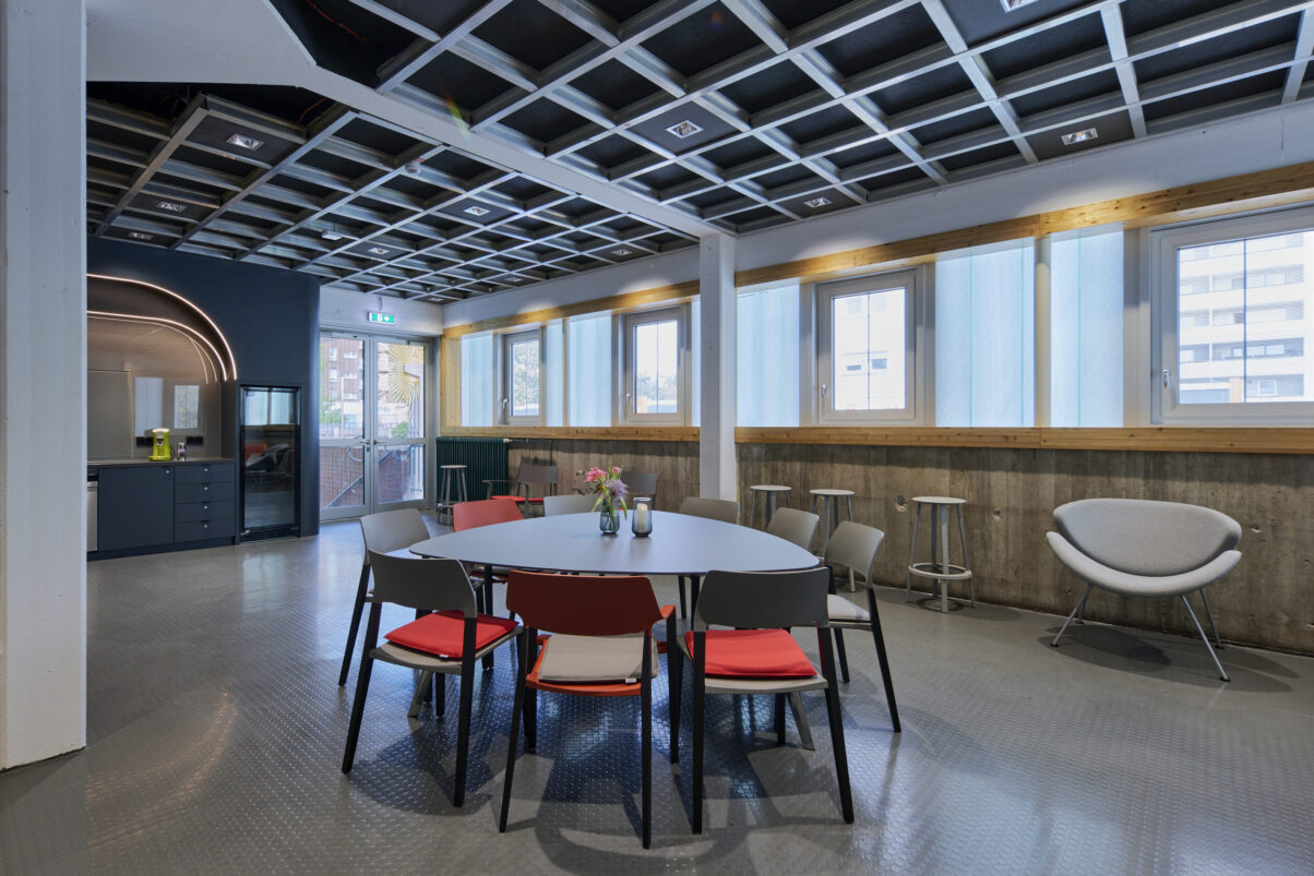 Architektur- und Interieurfotografie Düsseldorf Kulturhaus Süd, lichtdurchflutete Lounge mit Tisch, Stühlen, Barhockern
