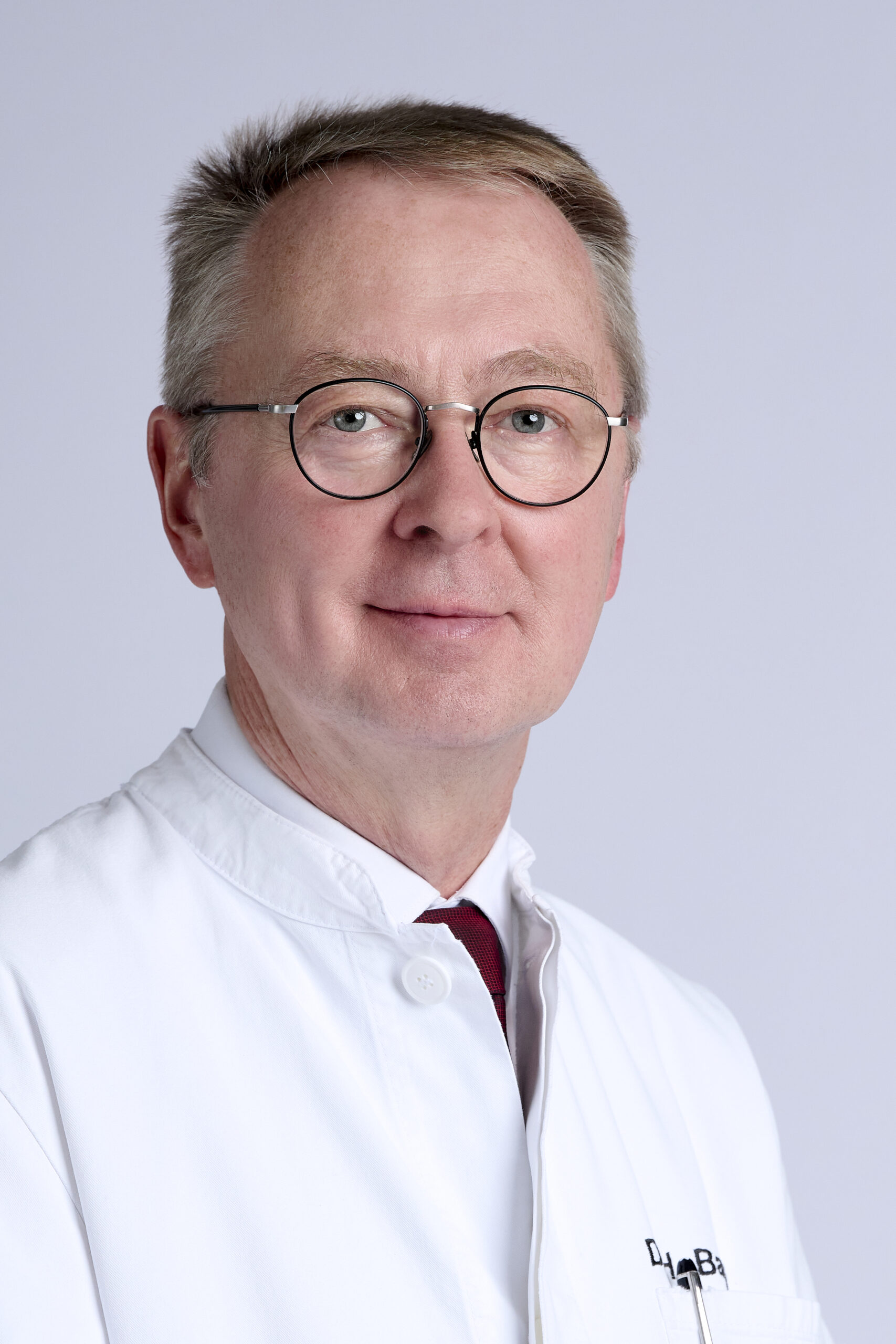 Peoplefotografie Düsseldorf, Business Porträts Düsseldorf Klassisches Businessporträt eines Arztes mit Brille vor hellem Hintergrund