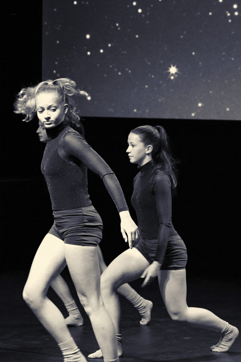 Eventfotografie Düsseldorf Ballettaufführung, moderne Choreographie, Tänzerinnen im sportlichen Look mit glitzerndem Rollkragen-Oberteil, Sternenhimmel, Blautönung