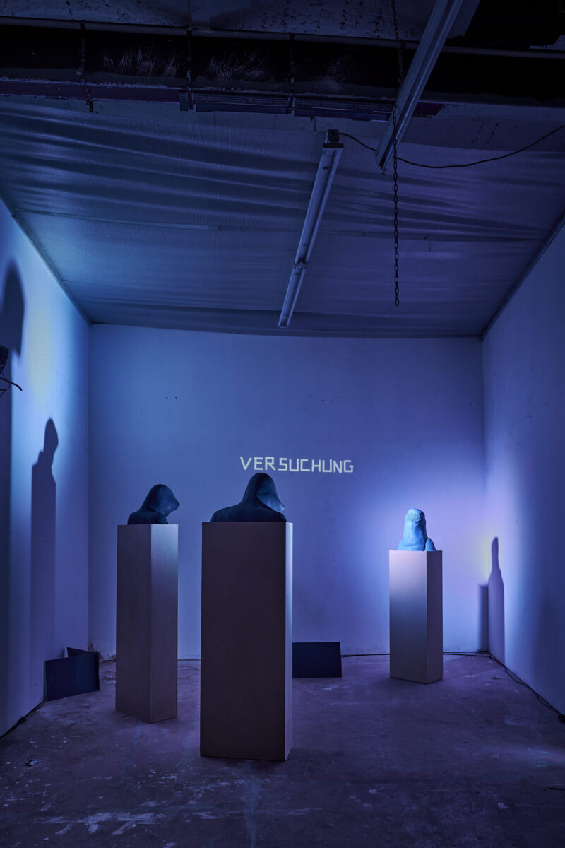 Eventfotografie Düsseldorf Ausstellung "72 Stunden - ein Zeitraum" von Corinna Bernshaus - Büste mit Burka, zwei Büsten mit Kapuze, blaue Tonskulpturen auf weißen Säulen und Lichtprojektion auf Wand