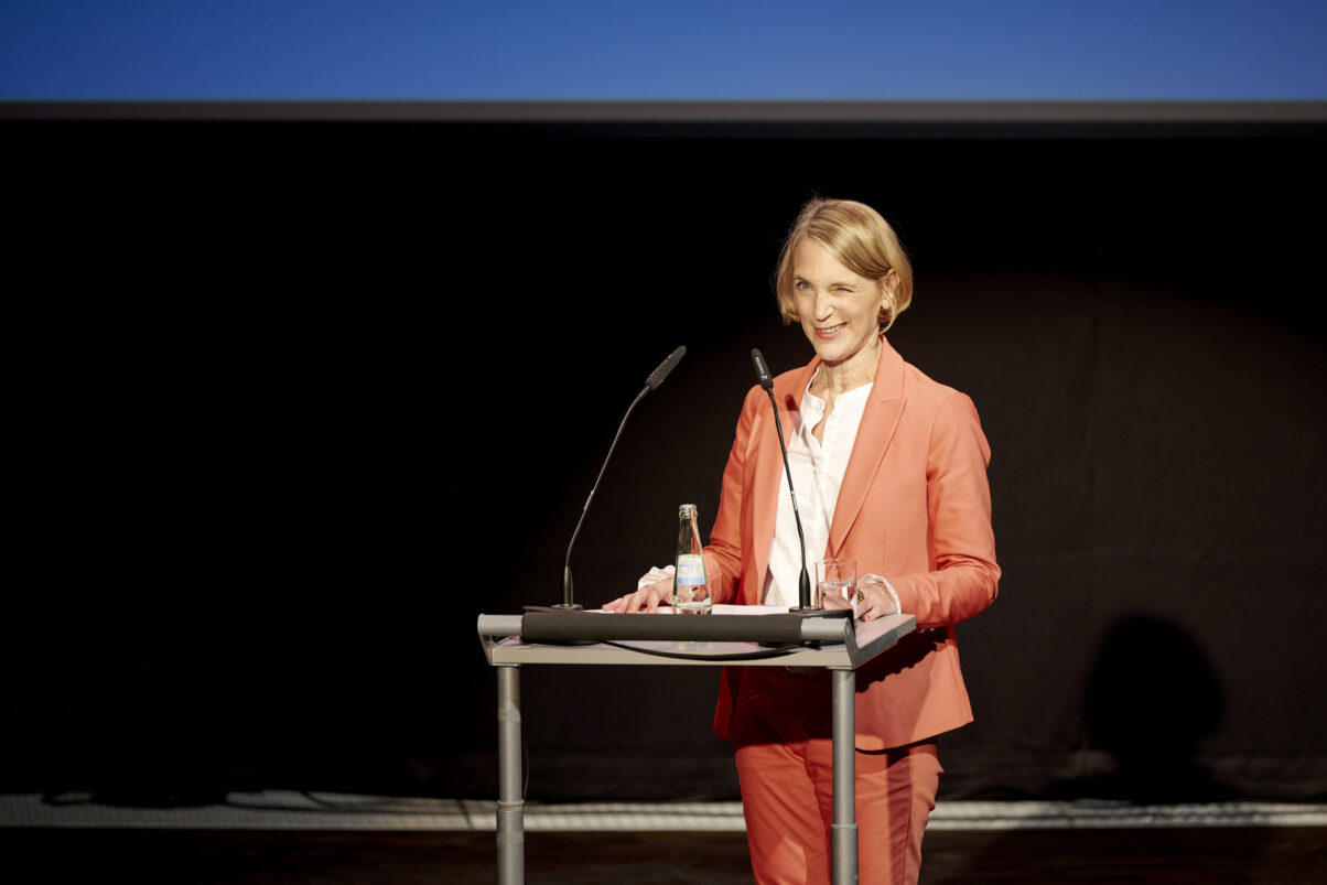 Eröffnungsgala Kulturhaus Süd - Eröffnungsansprache vor Publikum der Leiterin des Kulturhauses. Sie zwinkert mit dem linken Auge.