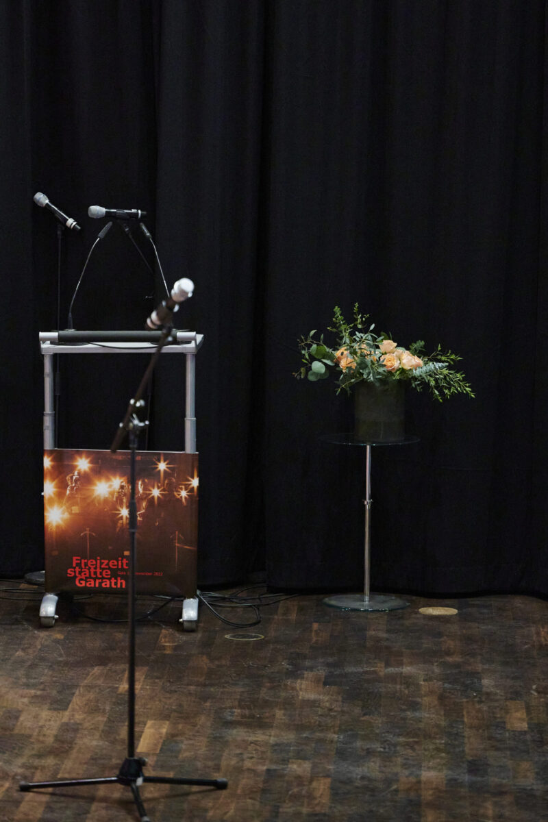Eröffnungsgala Kulturhaus Süd - Podium für die Redner mit groém Blumenstrauß und Mikrofon.