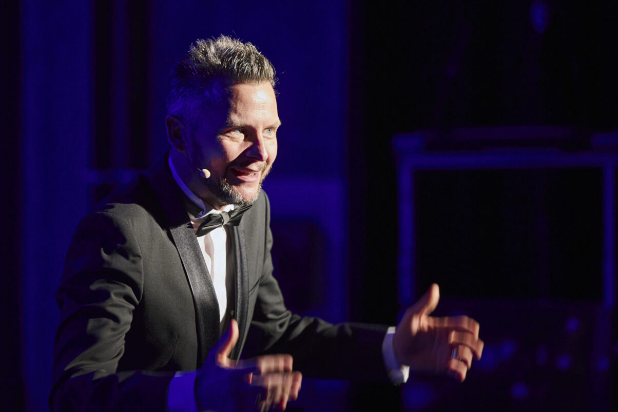 Eröffnungsgala Kulturhaus Süd - Comedian im schwarzen Smoking mit viel Humor schaut ins Publikum.