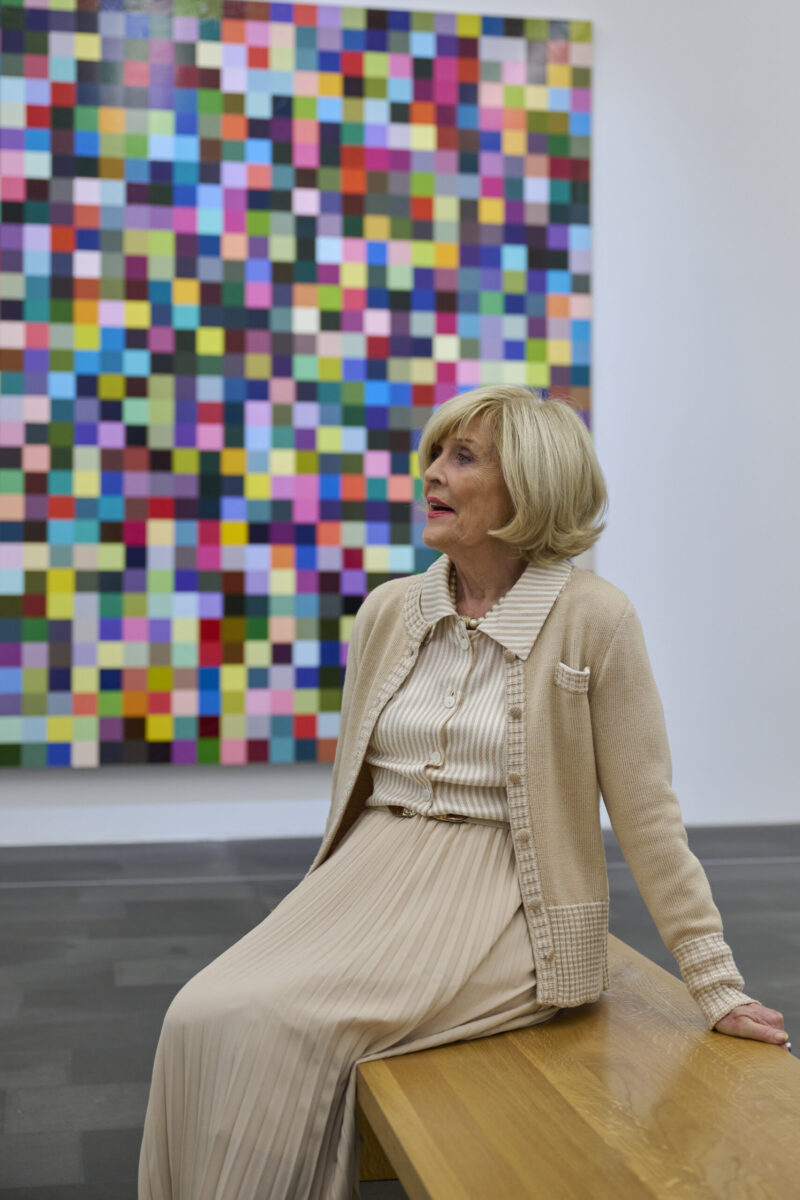 Ältere gut gestylte Dame im Museum im Hintergrund ein Mosaikgemälde von Gerhard Richter