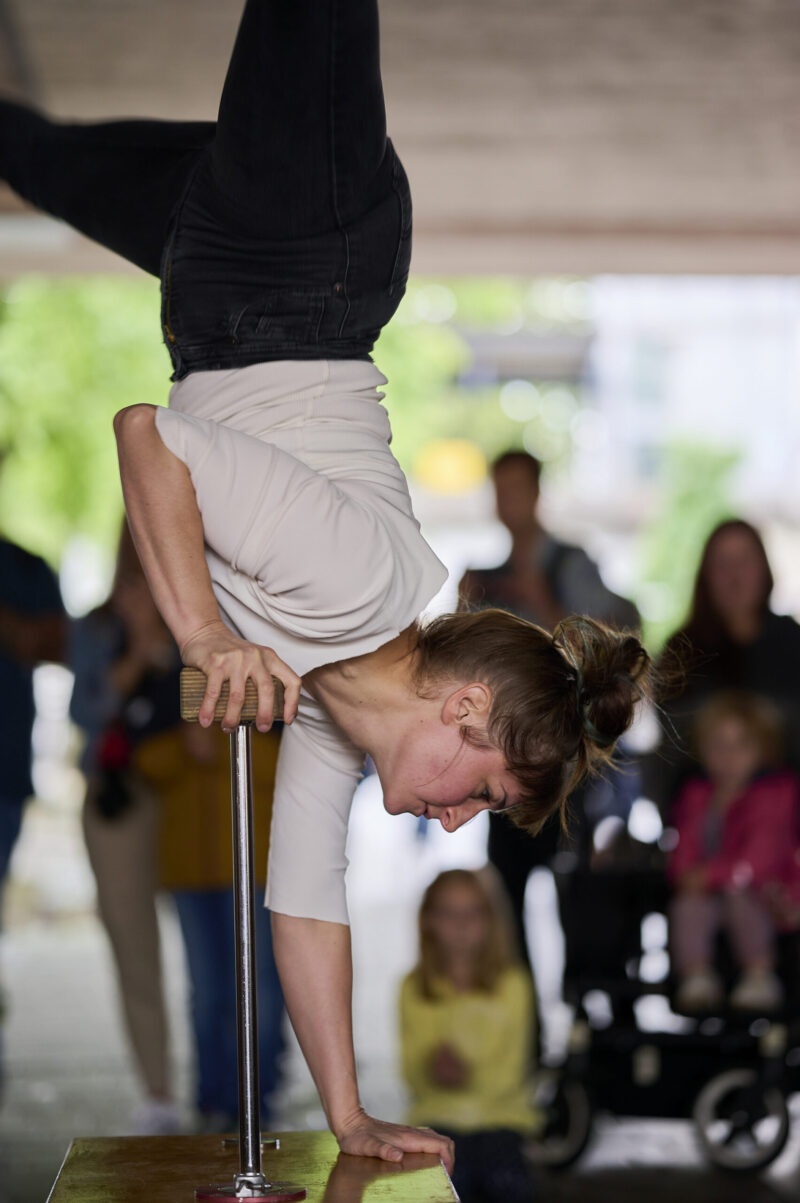 Pop up Artistik Festival, Artistin auf Händen jonglieren auf zwei Stangen