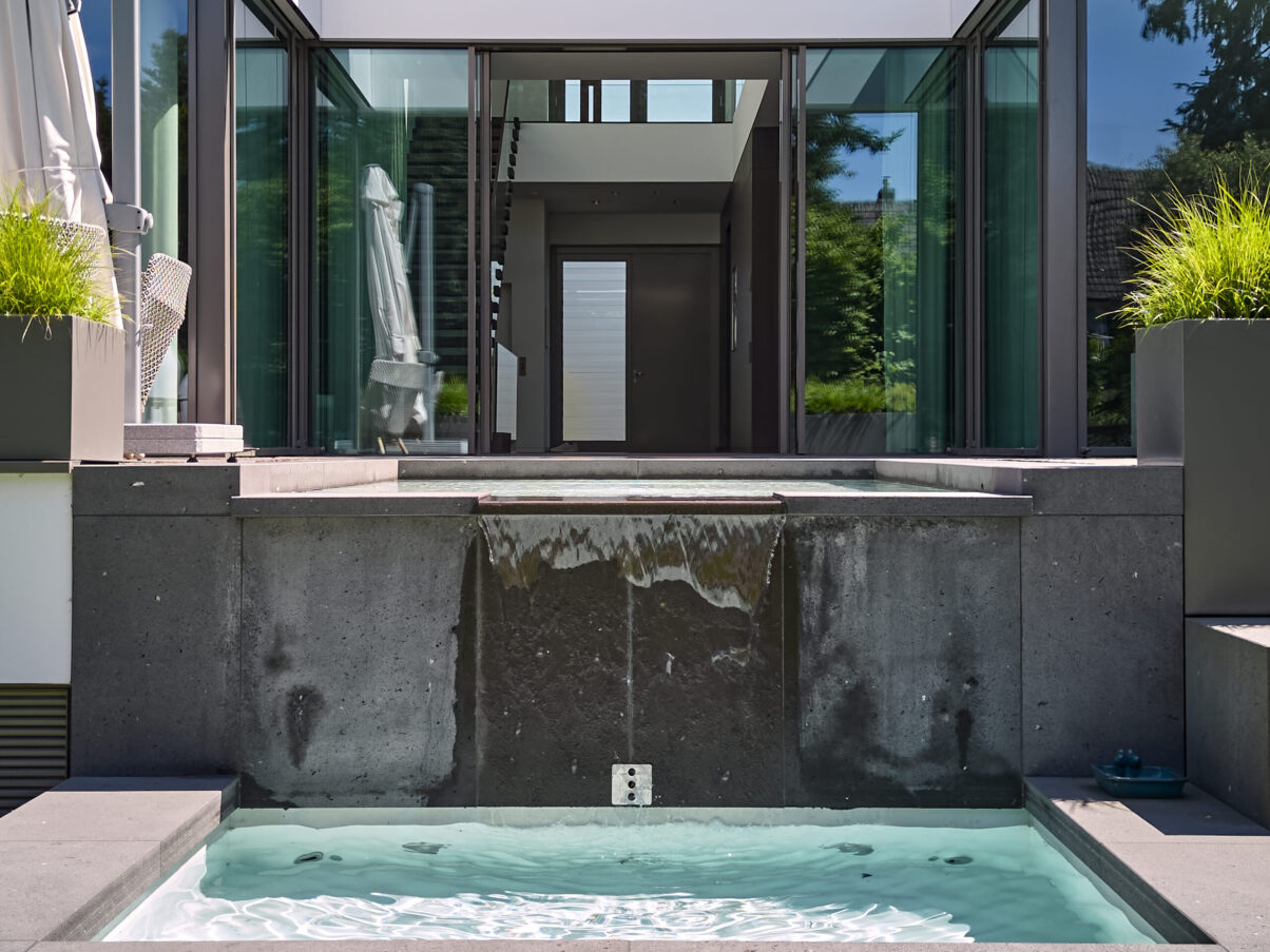 Architektur- und Interieurfotografie Düsseldorf MH Project, Durchsicht ins Haus und im Vordergrund der moderne zweistufige Brunnen