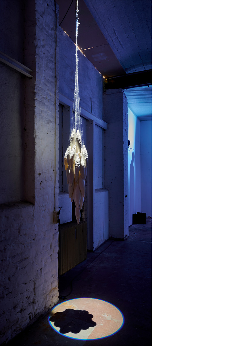 Eventfotografie Düsseldorf Ausstellung "72 Stunden - ein Zeitraum" von Corinna Bernshaus - von der Decke herabhängende Skulptur aus Porzellan -Spindeln, mystisch beleuchtet