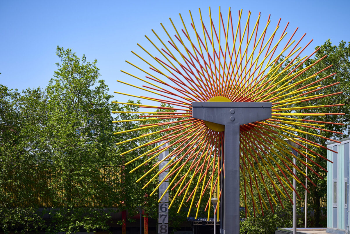 Eventfotografie Düsseldorf Sonnenrad Festival 2023 - Nahaufnahme eines großen Windrades in Sonnenfarben