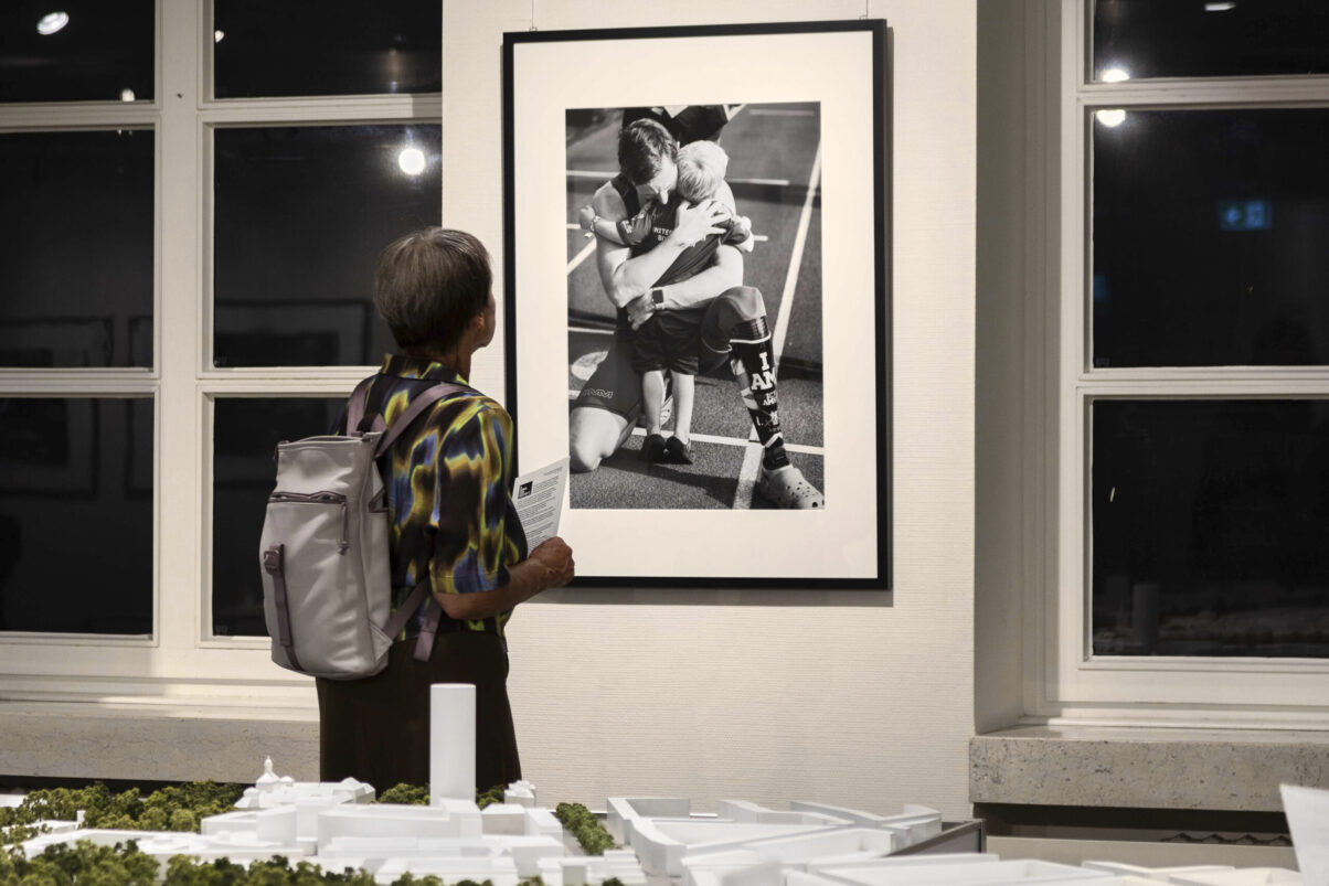 Ausstellung Spirit of Invictus Games Düsseldorf 2023 Besucherin betrachtet Bilder der Ausstellung im Rathaus
