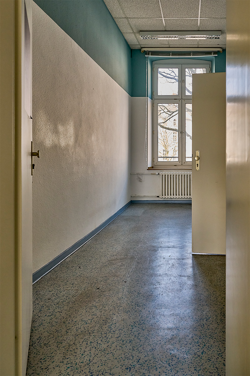 Architektur- und Interieurfotografie Düsseldorf SKFM Sanierung Altbau, Flur mit Linoleumboden und blauem oberen Wandstreifen und blauen Fußleisten