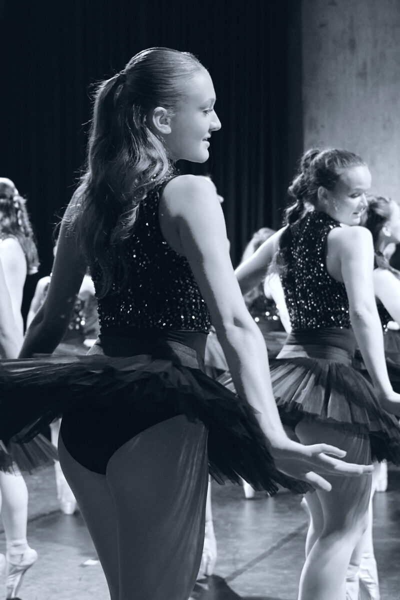 Eventfotografie Düsseldorf Ballettaufführung, klassische Choreographie, Tänzerinnen auf Spitzen posierend in klassischen, schwarzen "Schwanensee"-Kleidern mit Paillettenoberteil